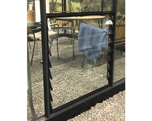 Ventilateur à lamelles JULIANA avec verre pour serre Compact 70x70 cm noir Gros plan d''une fenêtre avec des lamelles en verre dans un bâtiment