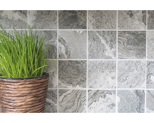 Carreaux muraux carrés avec motif marbré à côté d''un pot avec de l''herbe