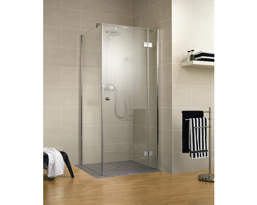 Douche d''angle avec robinetterie de douche et porte-serviettes dans une salle de bain