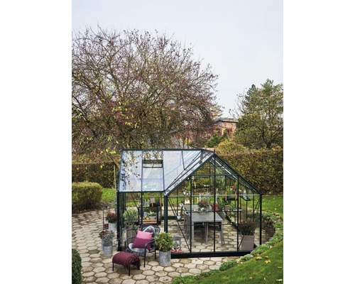 Serre avec table et chaises dans le jardin