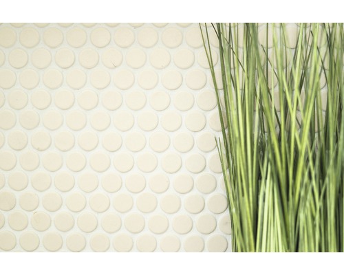 Nahaufnahme von runden Mosaikfliesen neben Kunstgras