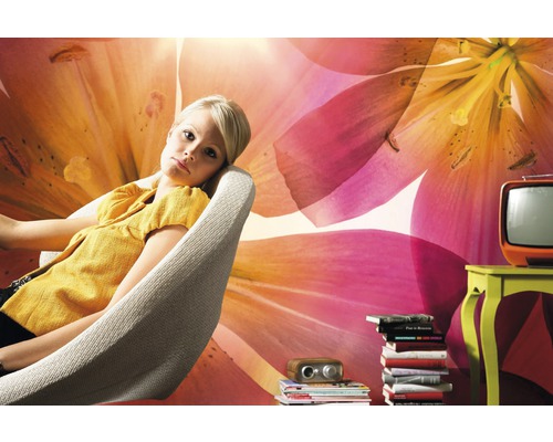 Salon décoratif avec une femme se relaxant dans un fauteuil devant un mur fleuri.