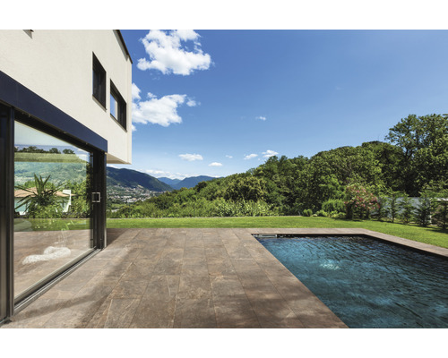 Terrasse avec dalles en pierre à côté d''une piscine et d''une maison