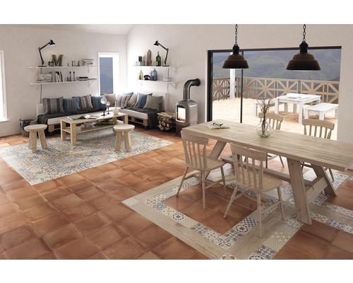 Wohnzimmer mit Sitzbereich, Tisch und Kaminofen auf Bodenfliesen