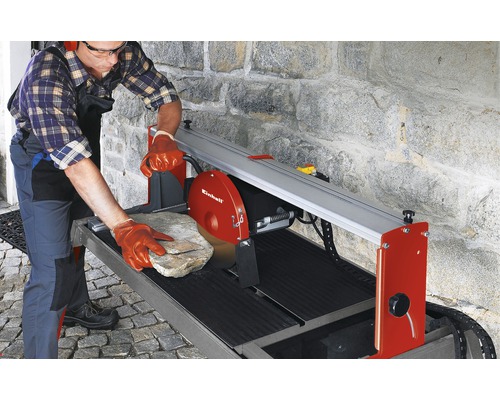 Un homme coupe une pierre avec une scie à pierre Einhell.