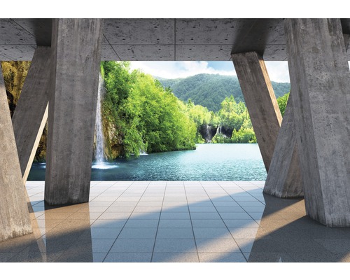 Papier peint panoramique intissé Seeblick bleu vert 312 x 219 cm Cadre de piliers en béton avec vue sur un lac avec des cascades et des arbres verts