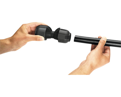 Installation d''un raccord de tuyau en PE noir par deux mains.