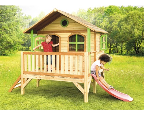Cabane de jeux en bois avec toboggan et deux enfants dans le jardin.