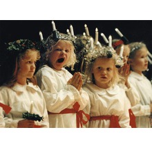 Eine Gruppe Kinder in traditionellen Lucia-Kostümen mit Kerzen