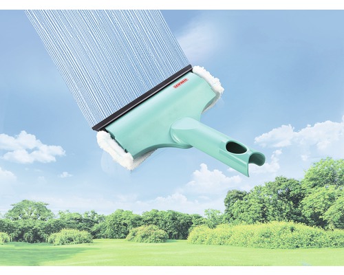 Lave-vitre avec réservoir d''eau et raclette devant un paysage