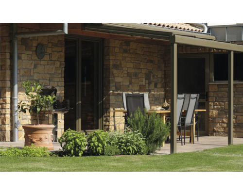 Terrasse avec mobilier de jardin, barbecue et mur en pierre