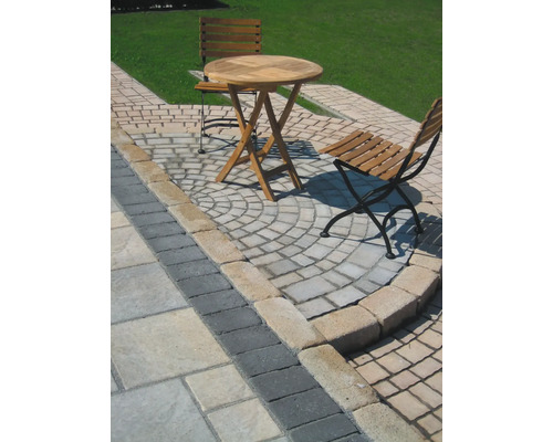 Gartenszene mit Pflastersteinen, Holztisch und Holzstühlen