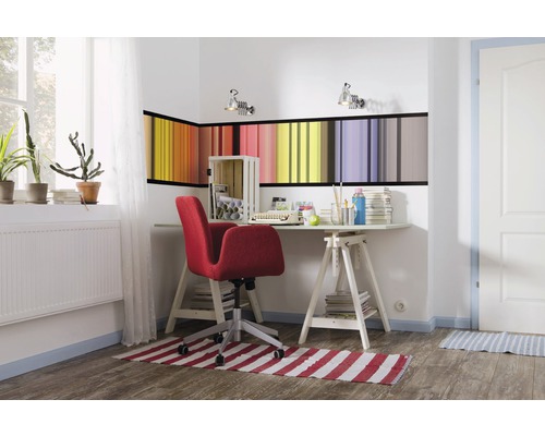 Bureau lumineux avec bureau, chaise de bureau rouge et décoration murale colorée