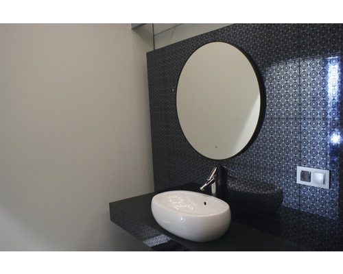 Salle de bains moderne avec miroir rond, lavabo en céramique et carrelage mural