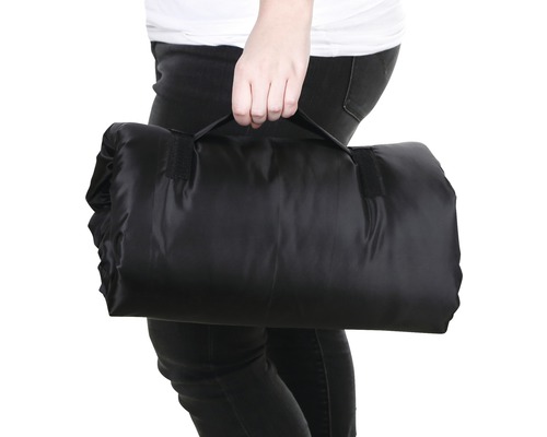 Zusammengelegte Picknickdecke mit Tragegriff in der Hand