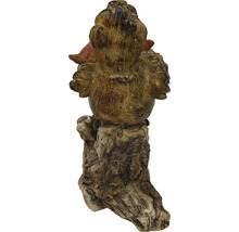 Gartenfigur eines Huhns auf Baumstumpf
