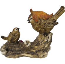 Dekorative Vogelfiguren auf einem Baumstamm mit einem Blatt als Zierde