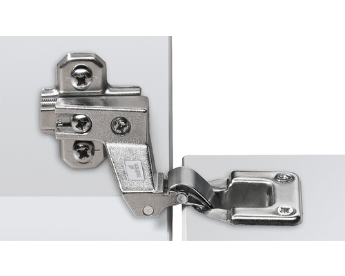 Möbelscharnier aus Metall an einer weißen Tür befestigt