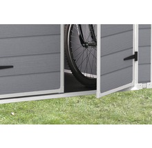 Vue détaillée d''un abri de jardin ouvert avec un vélo à l''intérieur.