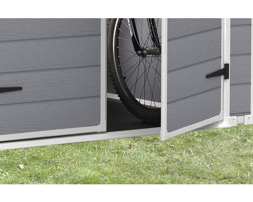 Vue détaillée d''un abri de jardin ouvert avec un vélo à l''intérieur.