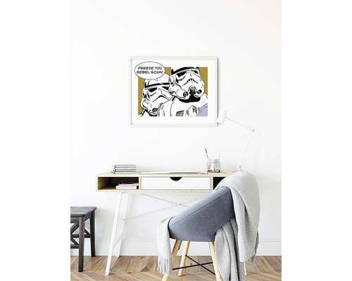 Un bureau avec un bureau, une chaise et une impression Star Wars encadrée au mur.