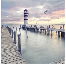Holzsteg führt zu einem Leuchtturm am See