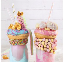 Zwei Milchshakes dekoriert mit Donuts, Marshmallows und Süßigkeiten