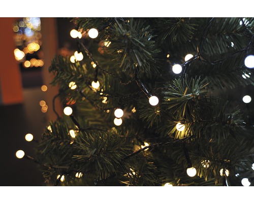 Gros plan d''un sapin de Noël avec une guirlande lumineuse