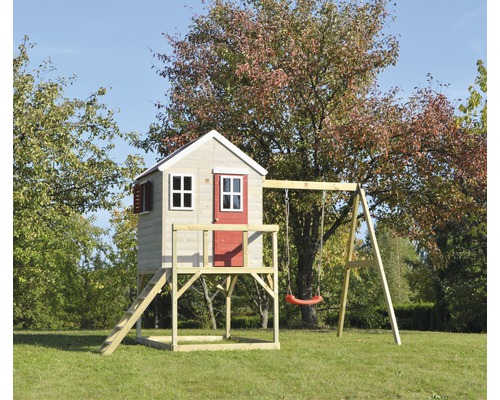 Maisonnette avec balançoire sur une prairie verte.