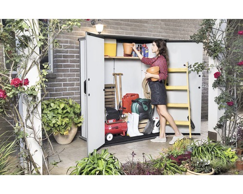 Scène de jardin avec une femme rangeant du matériel de jardinage dans une remise