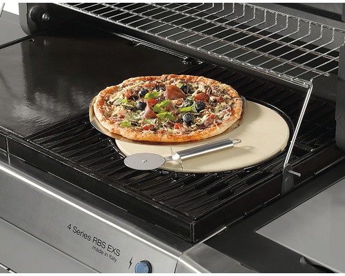 Pizza sur pierre à pizza avec roulette à pizza sur un barbecue