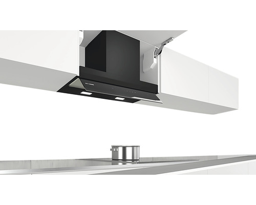 Dunstabzugshaube zwischen Küchenschränken über einem Kochfeld mit einem Topf