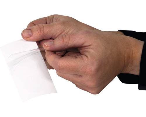 Les mains retirent le film protecteur du film autocollant