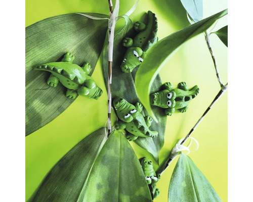 Figures décoratives de crocodile entre des feuilles vertes