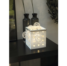 Boîte décorative en bois avec des étoiles et une guirlande lumineuse sur une table.