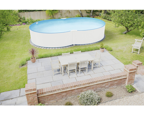 Vue du jardin avec piscine et table à manger sur la terrasse