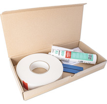Mastics, ruban adhésif et accessoires dans une boîte en carton ouverte.