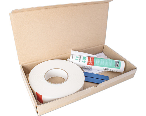 Mastics, ruban adhésif et accessoires dans une boîte en carton ouverte.