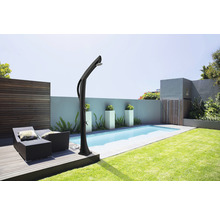 Scène de jardin avec piscine, chaises longues et douche de jardin.