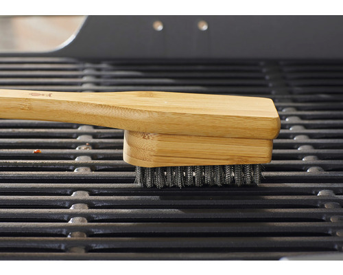 Grillbürste mit Bambusgriff auf einem Grillrost