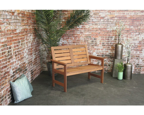 Banc en bois d''extérieur devant un mur en briques avec des plantes