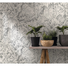 Papier peint à motif de plantes derrière une table avec des plantes d''intérieur