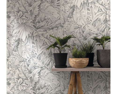 Papier peint à motif de plantes derrière une table avec des plantes d''intérieur