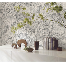 Pièce décorative avec un papier peint à motifs de plantes tropicales derrière une armoire blanche