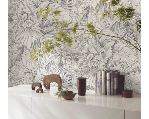 Pièce décorative avec un papier peint à motifs de plantes tropicales derrière une armoire blanche