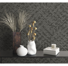 Dekoratives Stillleben mit Vasen, Buch und Kerze vor gemusterter Wand