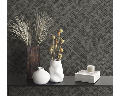 Dekoratives Stillleben mit Vasen, Buch und Kerze vor gemusterter Wand