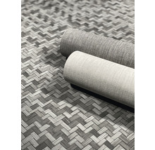 Zwei gerollte Teppiche auf einem gemusterten Untergrund