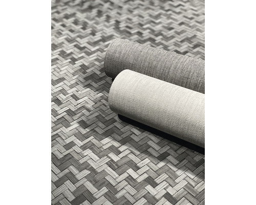 Zwei gerollte Teppiche auf einem gemusterten Untergrund