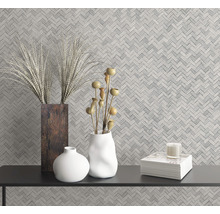 Wandgestaltung mit Fischgrätmuster und Dekorationsgegenständen auf einem schwarzen Tisch